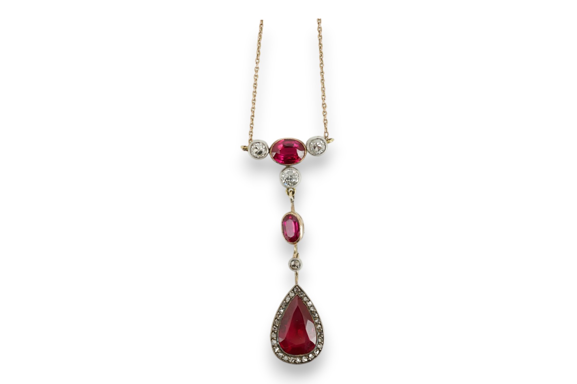 A 9ct, three stone synthetic ruby and four stone diamond set drop pendant necklace, pendant section 49mm, gross weight 5.2 gram.